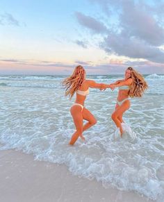 two beautiful women in bikinis playing in the ocean