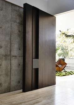 an open door leading into a room with concrete walls and flooring on either side