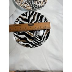 two zebra print plates with a measuring tape