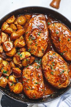 chicken and potatoes in a skillet with parsley sprinkled on the side