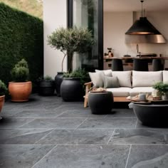 an outdoor living area with potted plants and couches