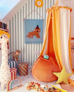 a child's playroom with toys and decor on the floor, including a giraffe tent