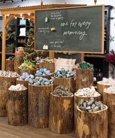 several logs are stacked up in front of a chalkboard with writing on it and other decorations