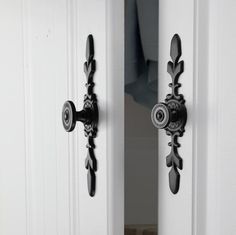 an ornate door handle on a white front door with black trim and decorative knobs