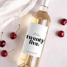 a bottle of wine sitting on top of a table next to some cherries and a napkin