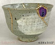 a white bowl with purple and gold designs on it