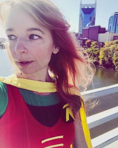 a woman in a life jacket standing on a bridge looking at the camera and smiling