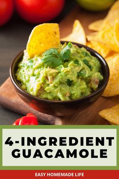 guacamole in a bowl with tortilla chips and tomatoes on the side