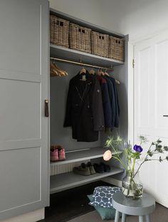 an organized closet with clothes and shoes hanging on the rack, next to a stool