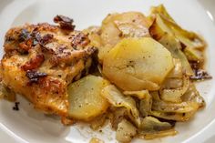 a white plate topped with chicken, potatoes and artichokes