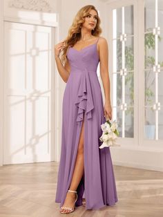 a woman wearing a purple bridesmaid dress and holding a bouquet in her hand