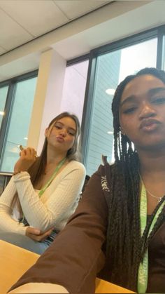 two young women sitting at a table in an office