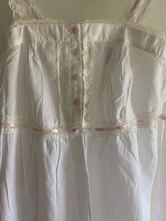 Very cute and summery vintage Laura Ashley nightgown  NWT in pink and white! Cute floral pink buttons Pink ribbon straps do not adjust Ties at back.  Underbust at is slightly elasticized.   Lightgweight cotton.  Super summery! Medium size per tag Bust flat at front is 16 inches Underbust is 15 inches.  Elasticized at back.  Length is 44-45 inches.  Final sale. No returns🌺🌺 Summer Nightgown With Buttons, White Cotton Cottagecore Sleepwear, White Cotton Buttoned Sleepwear, White Cotton Sleepwear With Buttons, Cute White Summer Nightgown, White Cottagecore Cotton Sleepwear, Cottagecore White Sleepwear With Lace Trim, White Cottagecore Sleepwear With Lace Trim, Summer Sleepwear With Buttons For Sleepovers