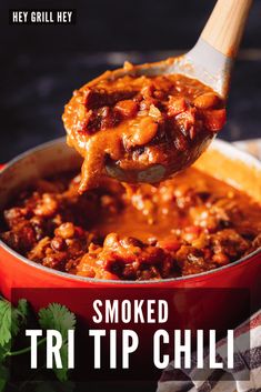 a spoon full of chili sauce being lifted from a red casserole dish