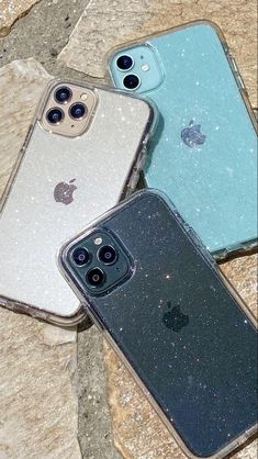 three iphones sitting next to each other on some rocks