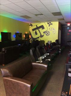 a room filled with lots of black couches and gaming controllers on top of them