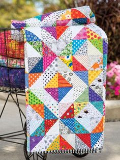 a colorful quilt sitting on top of a metal cart