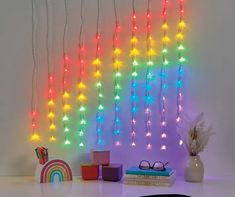 multicolored lights hang from the ceiling above a table with books and other items