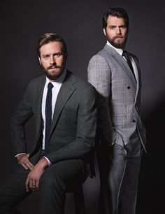 two men in suits posing for the camera