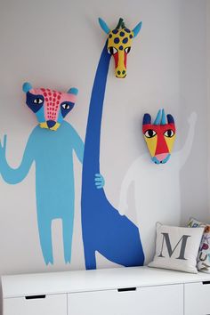 two giraffes are painted on the wall next to each other in this children's room