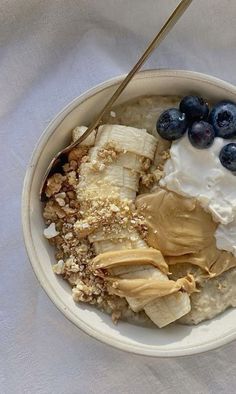 a bowl filled with oatmeal and blueberries on top of a white cloth