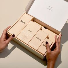 a woman's hands holding an open box with six boxes in it