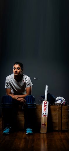 a man sitting on top of a wooden crate next to a bat