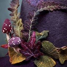 a purple hat with leaves and mushrooms on it