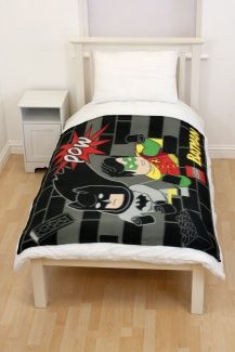 a bed with a black and white bedspread on top of wooden flooring