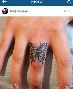 a hand with a butterfly tattoo on it