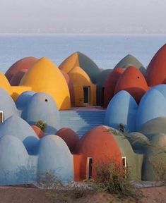 colorfully painted domes sit in front of the ocean