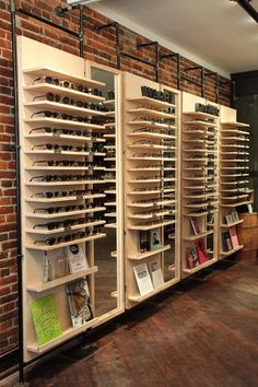 the shelves are full of books and magazines in this room with exposed brick wall behind them