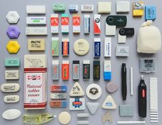 an assortment of various items are laid out on a gray surface, including toothbrushes and combs