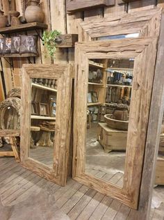 two mirrors sitting next to each other on top of a wooden floor in a room