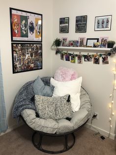 a room with several pillows and pictures on the wall