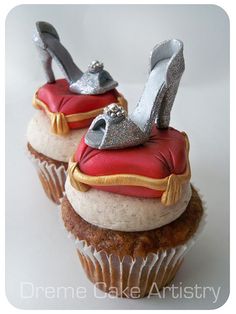 two cupcakes with high heel shoes on top, one is red and the other is gold