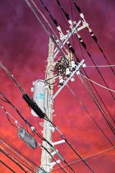 an electric pole with many wires attached to it and the sky in the back ground