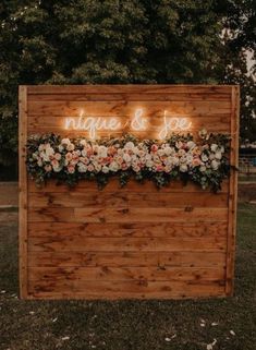 a wooden sign with flowers on it that says unique and joy written in neon lights