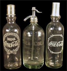 three old fashioned glass bottles are lined up