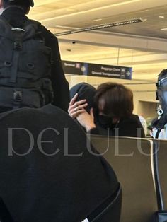 an airport security officer standing in front of people waiting for their bags to be picked up