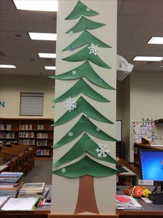 a christmas tree made out of paper on top of a book shelf in an office