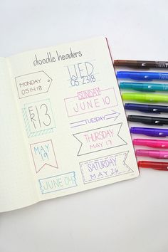 an open notebook with markers and pencils next to it