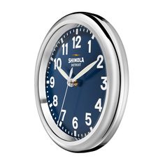 an analog clock with the word shinola on it's face is shown in silver and blue