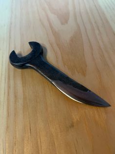 a black knife sitting on top of a wooden table