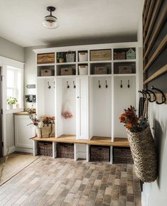 a room filled with lots of white cupboards and shelves next to a door way