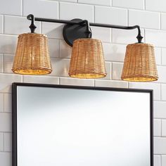 a bathroom with a mirror and three lights on the wall, next to a light fixture