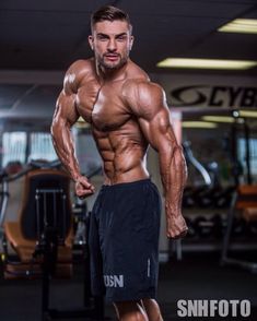 a man posing in the gym with his muscles ripped and showing off his bulging chest