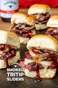 several sliders with bbq sauce on them sitting on a cutting board next to ketchup