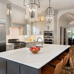 a bowl of fruit is sitting on the kitchen island