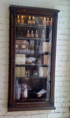 a display case filled with lots of different types of spices and condiments in front of a brick wall